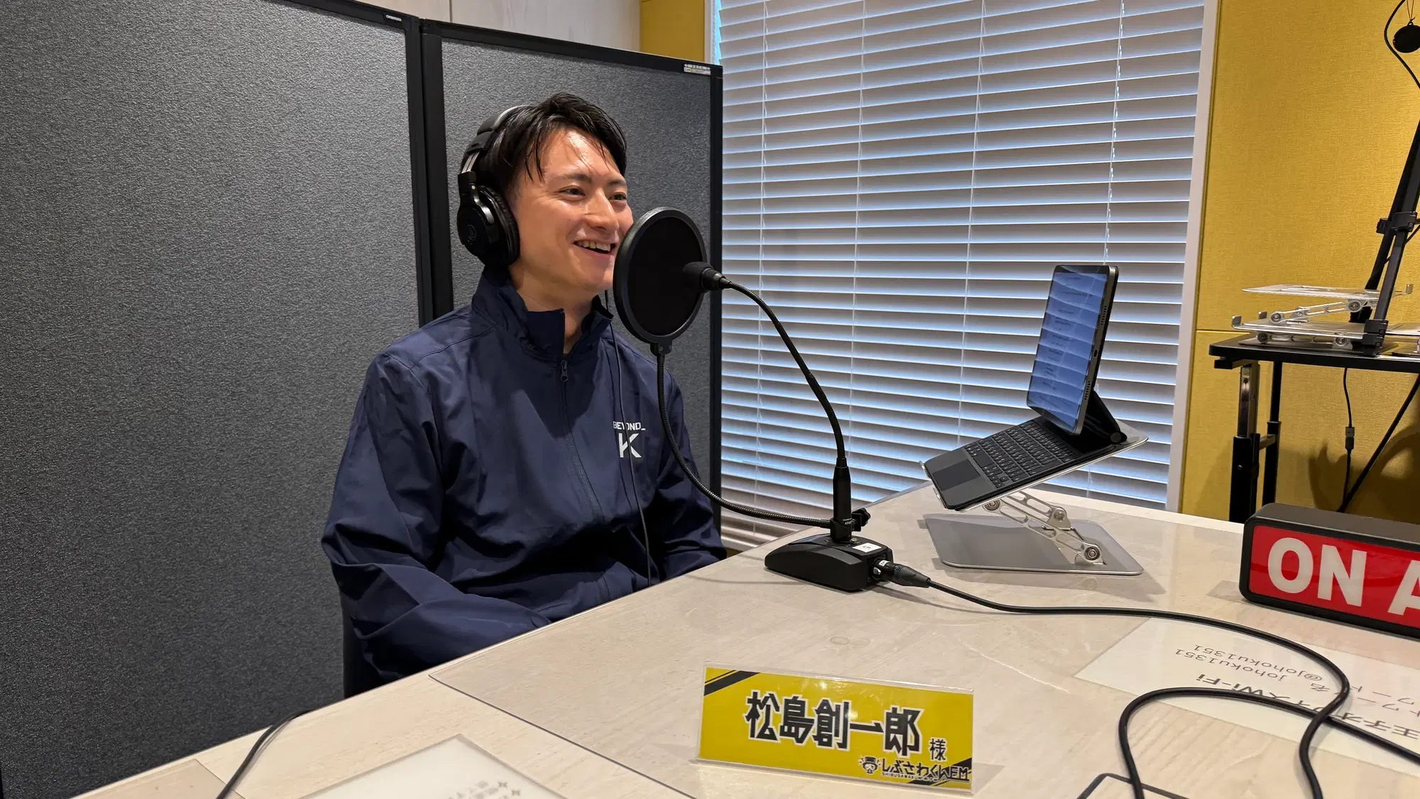 マイクの前で話す代表の松島